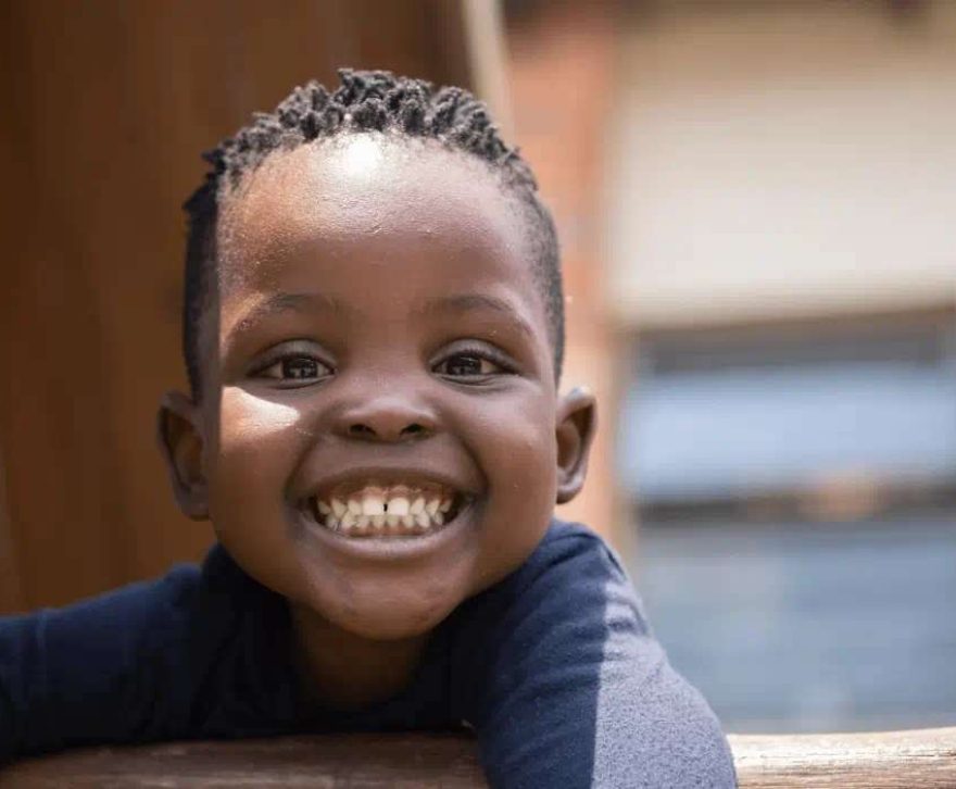 A young child smiling at an Afrika Tikkun early learning centre