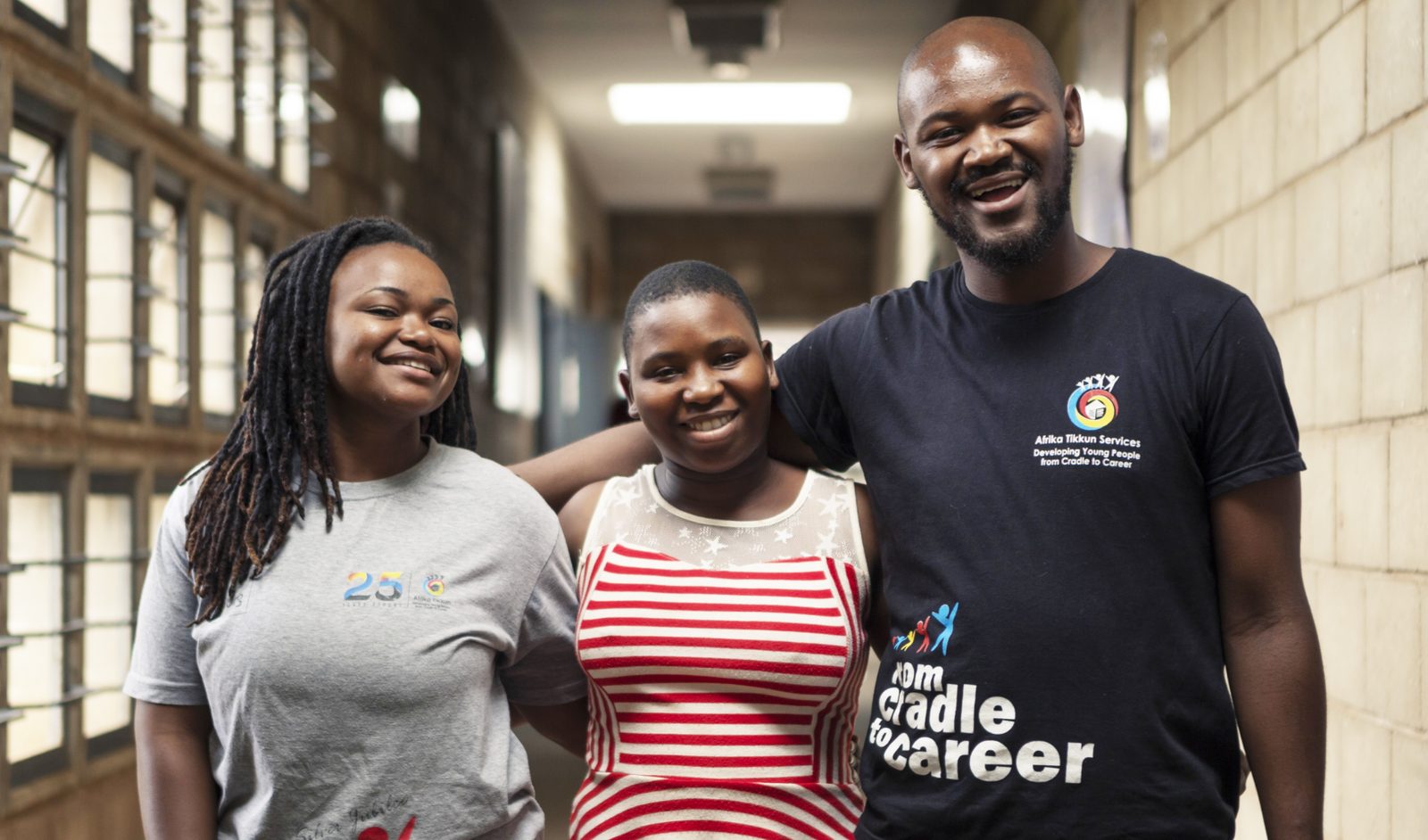 Young adults in Afrika Tikkun Cradle to Career shirts at a centre